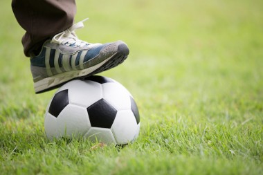 Close up of feet on top of soccer ball