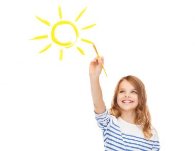 cute little girl drawing sun with brush