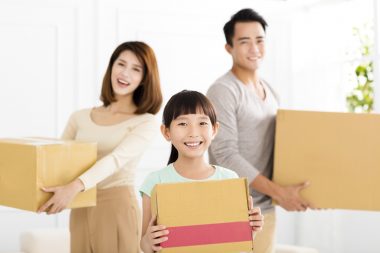 happy family holding box moving to new home